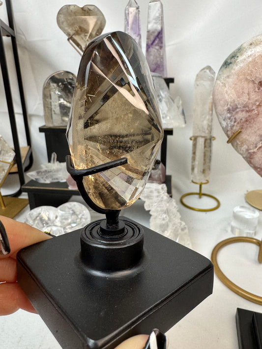 Faceted Smoky Quartz Crystal with golden rutile on spinning stand